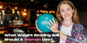Woman holding teal bowling ball in bowling alley, smiling